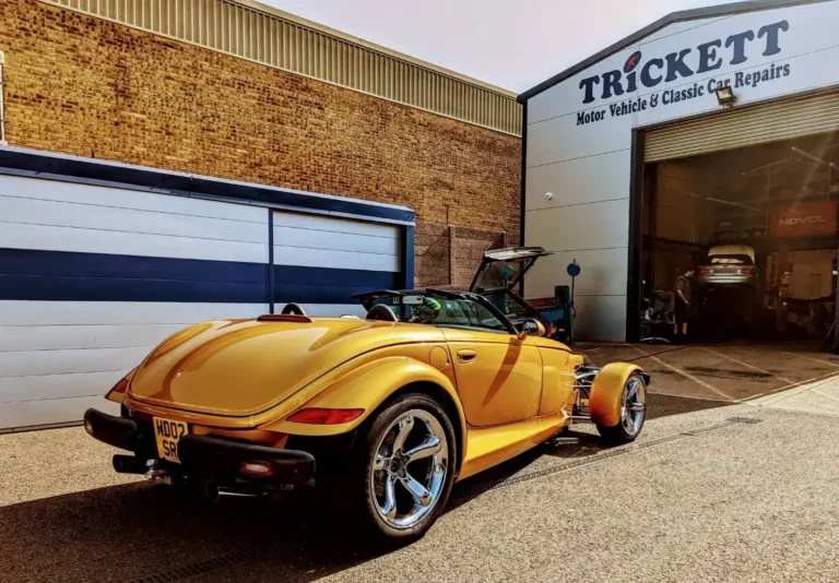 Gold Plymouth Prowler sports car outside Trickett Welding Ltd workshop