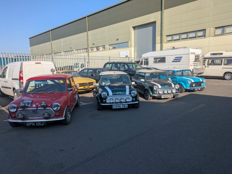 Classic Mini collection parked outside Trickett Welding's classic car restoration workshop.