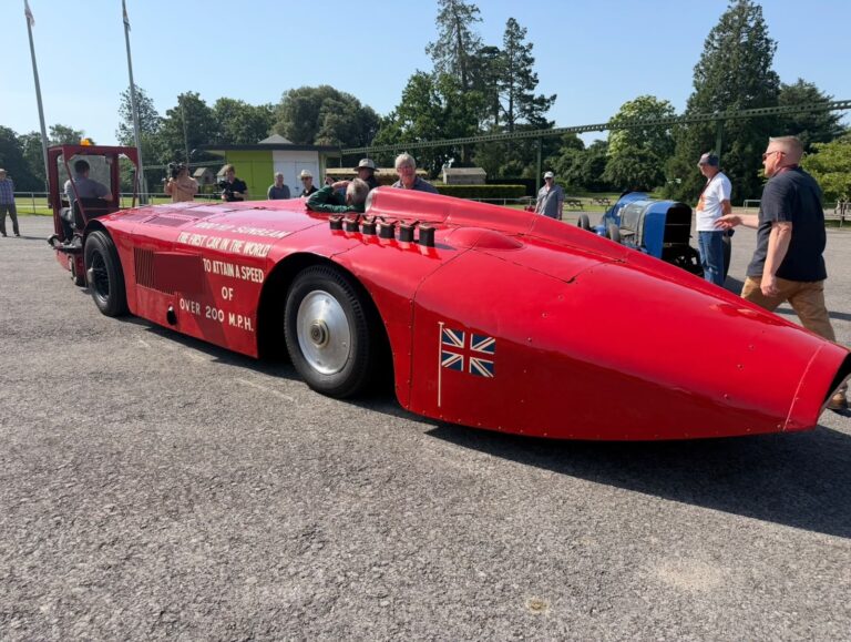 Historic red Sunbeam 1000 HP land speed record car displayed at a classic motoring event.