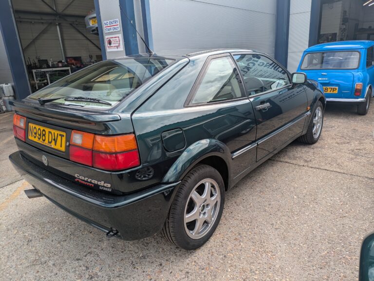Dark green Volkswagen Corrado VR6 parked outside Trickett Welding's vehicle restoration workshop.