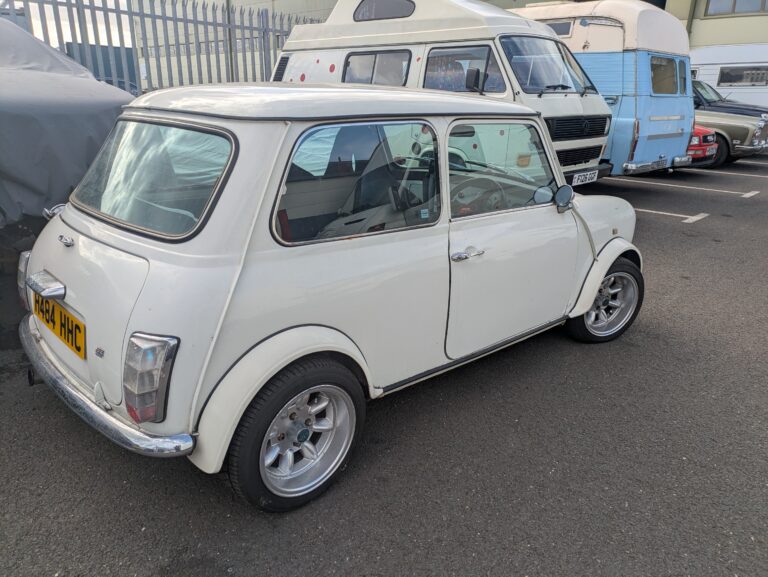 White classic Mini with alloy wheels parked outside Trickett Welding's classic car restoration workshop.